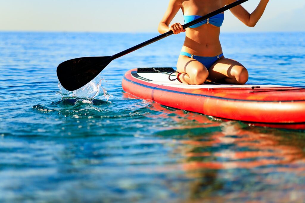 sporty fitness woman on SUP board at sunny nice day on sea