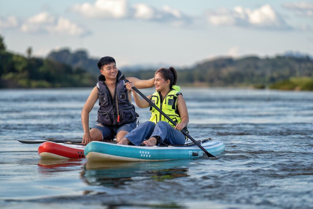 On summer holiday love couple relax sail sup board surf on river on beautiful nature calm river