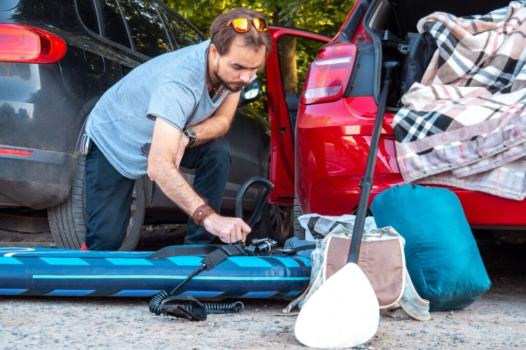 Young man preparing sup board for riding