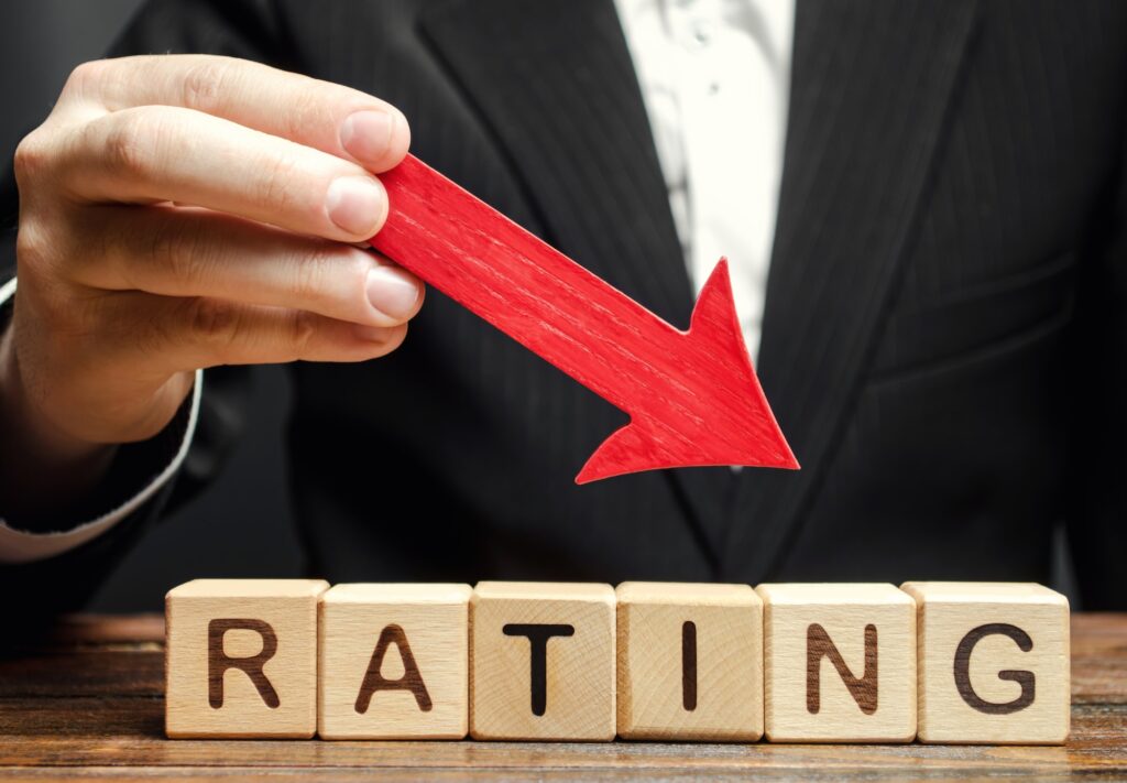 A man holds a red down arrow above the word Rating