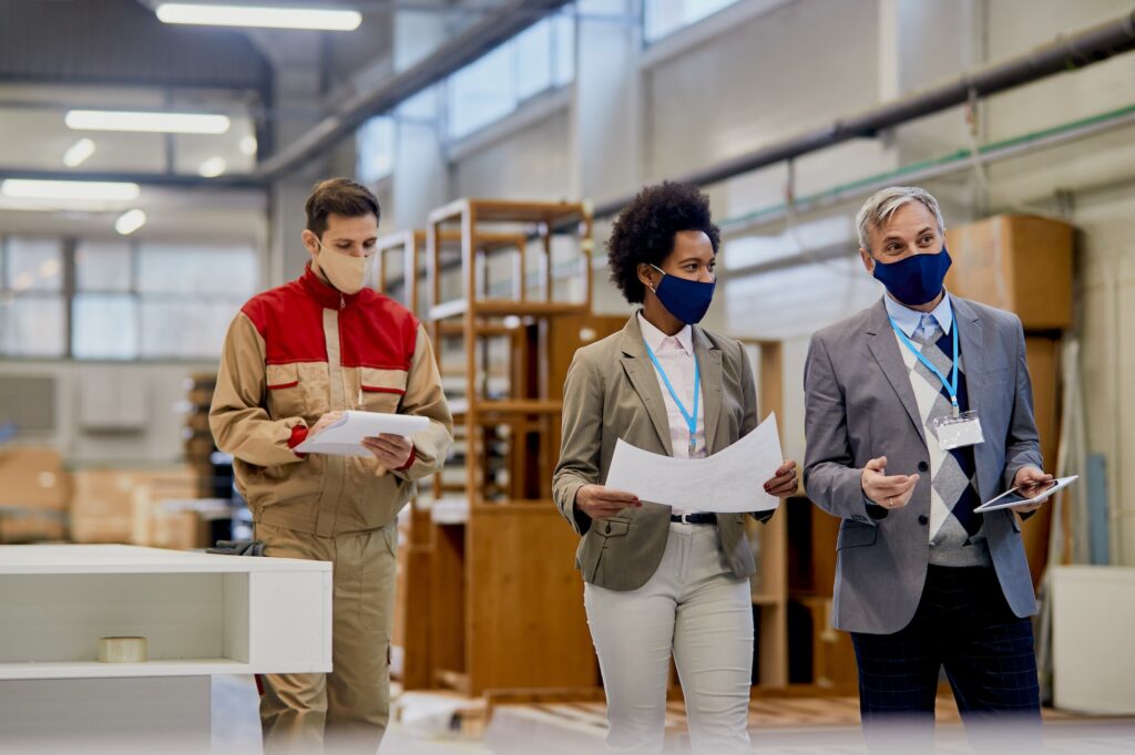 Quality control inspectors walking through woodworking facility during coronavirus pandemic.